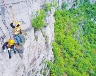 捅山工百米高空作业，为保障山下列车通行安全